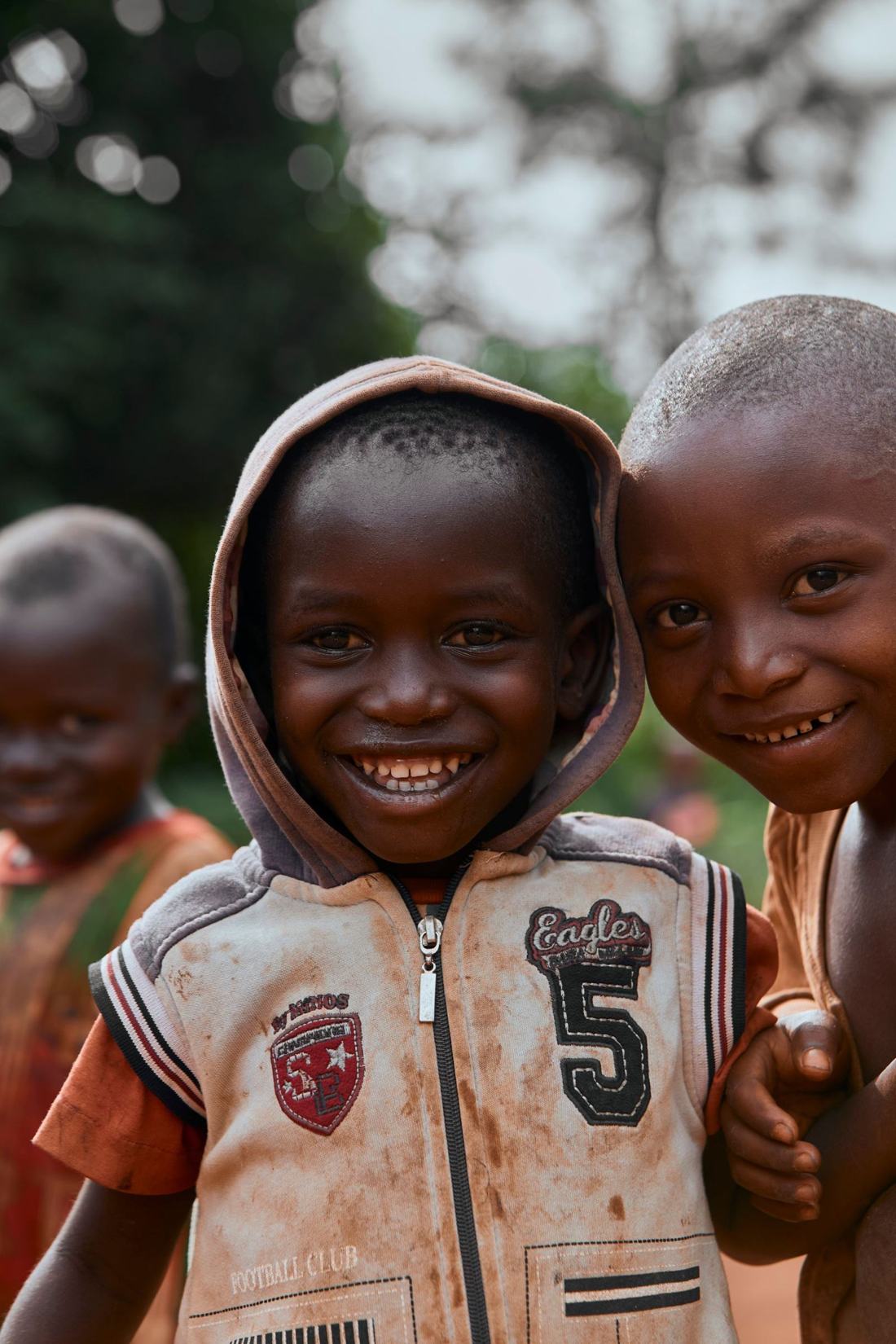 Three children smiling together outdoors