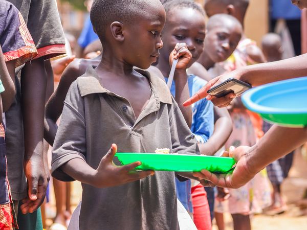 A boy holding out his plate to be served