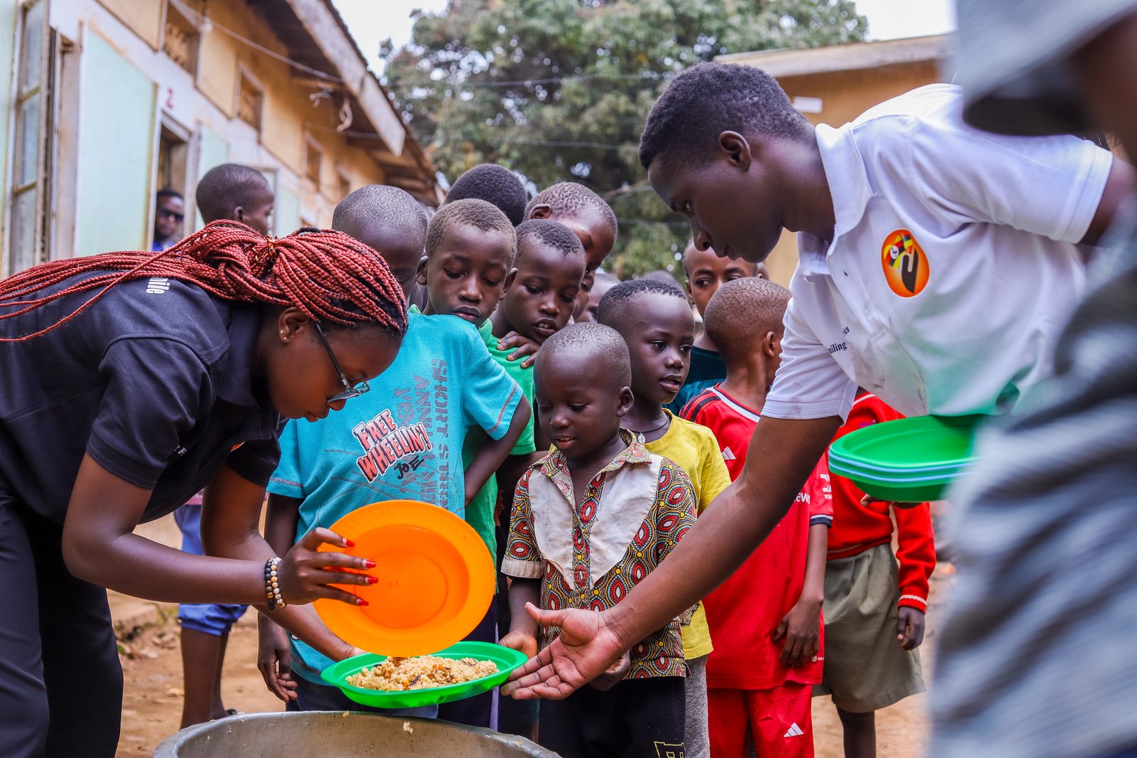 Our team serving food to a line of children at an outreach day