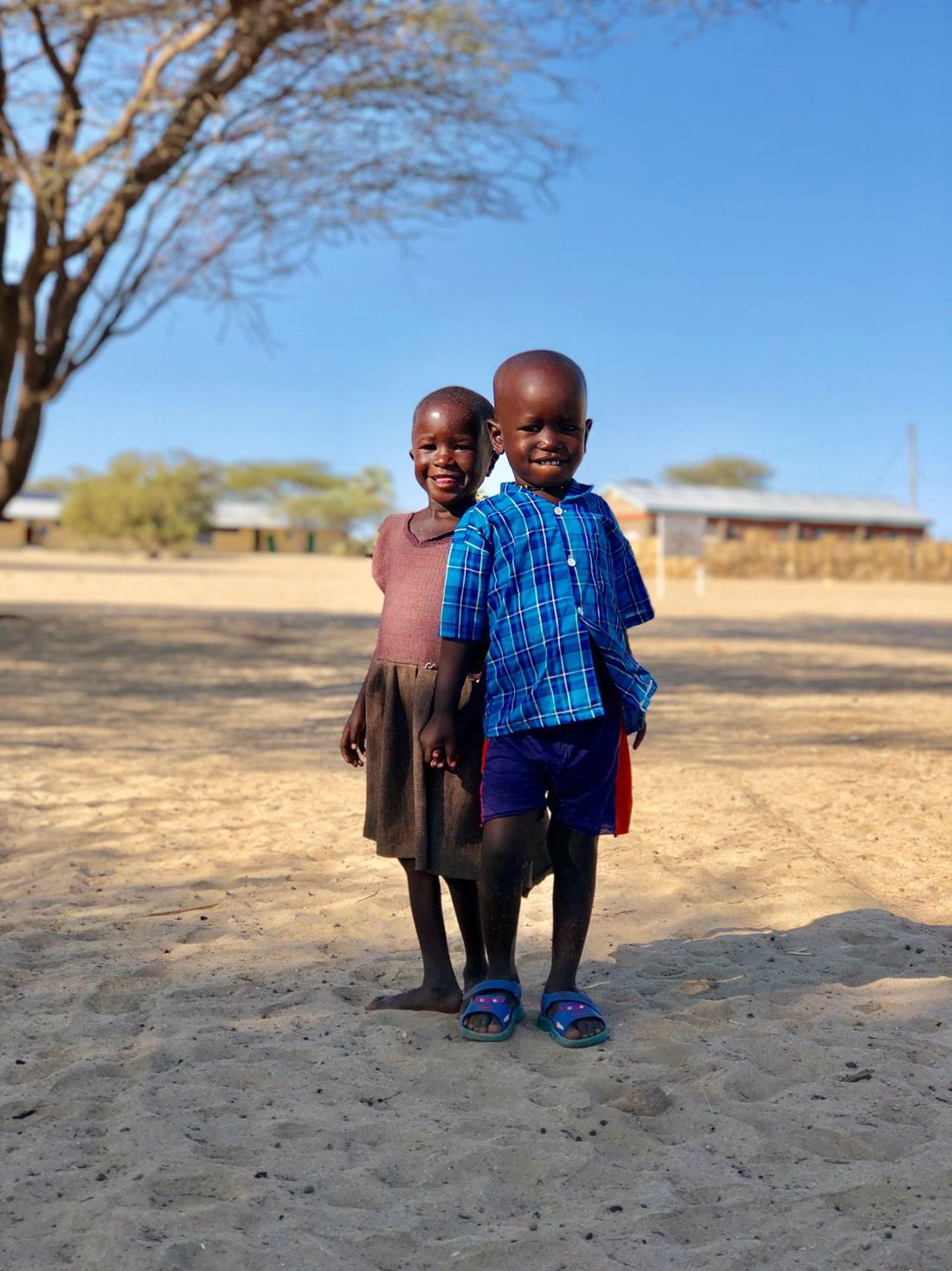 Two young siblings standing outdoors