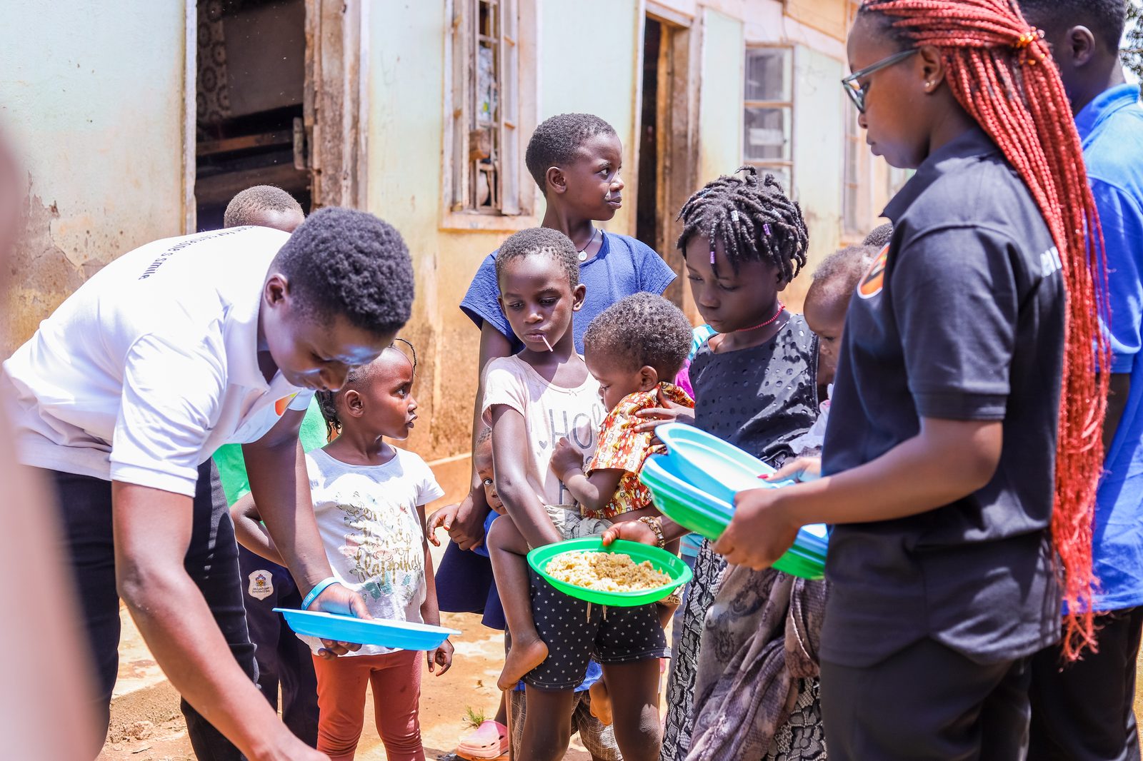 Our team serving hot food from a large pot to children